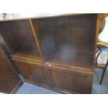 An early 20th century oak bookcase having four loose shelves above two panelled cupboard doors 54