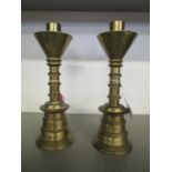 A pair of early 20th century heavy brass turned candlesticks of stepped form