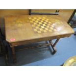 A Victorian walnut side table having a chequerboard top and turned supports 27 3/4" H x 35 3/4" W