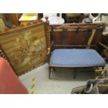 An Edwardian mahogany two-seater salon sofa with upholstered seat and pierced centre splats on