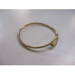 A 9ct gold bangle with a dolphin terminal