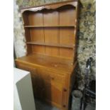 A light oak carved dresser, the top with two plate shelves above a base with two short drawers and