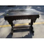 A Victorian carved oak table with single frieze drawer flanked by lion head masks with brass ring