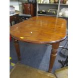 A late 20th century stained pine oval dining table with turned legs