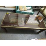 A metal framed and glass topped coffee table with two inset relief plaques depicting knights in