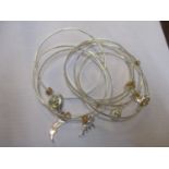 A six bangle bracelet in white metal together with six charms, two of which are Tiffany silver