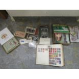 A collection of Edwardian and later postcards, cigarette cards and stamps some mounted in albums