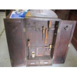 A 1930s oak finished, twin door, wall mounted tool cabinet, containing a small assortment of tools
