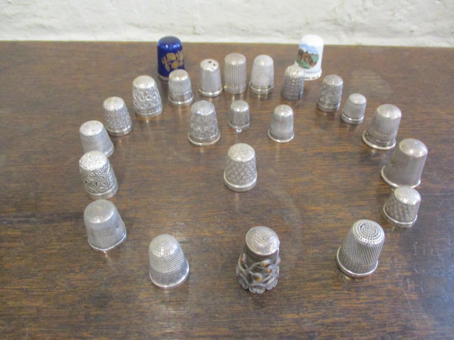 A collection of thimbles to include silver examples. Total weight of metal thimbles, 102g