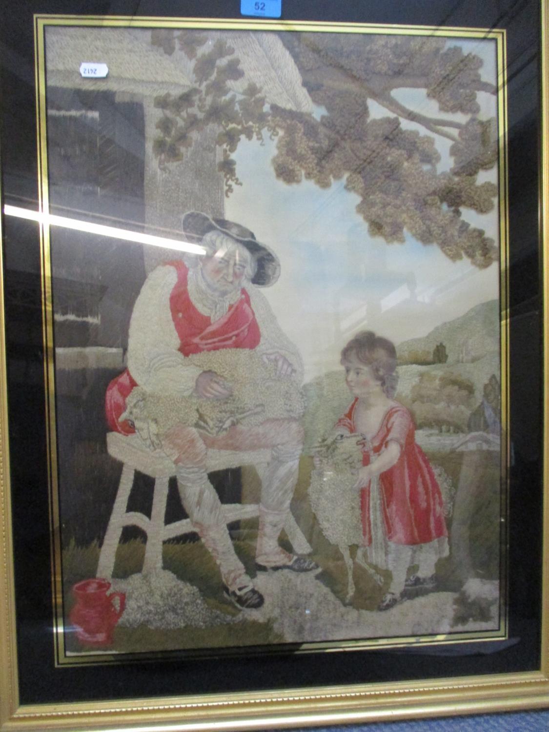 A late 19th century wool and silk picture of a shepherd and his daughter tending sheep by a barn A/F