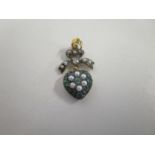 A silver heart shaped pendant set with emeralds, diamonds and seed pearls