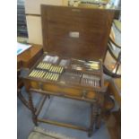 A 1920's oak Mappin & Webb cutlery table having a hinged top with drawer below containing fitted and