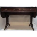A Regency mahogany sofa table with twin fall flaps, over two in line drawers with facsimiles to
