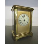 Ab early 20th century brass cased carriage clock, five windows with cream enamelled Roman dial, (