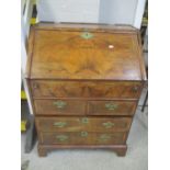 An early 20th century walnut Queen Anne inspired bureau having a fall flap above four drawers 38"h x