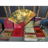 A selection of Asian items to include a boxed chopstick set, an album of Korean postage stamps, fans