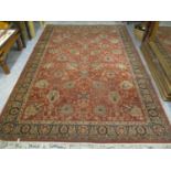 A machine woven red ground rug having a flora design and multiguard borders, 118" x 79"