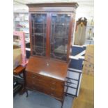 An early 20th century mahogany bureau bookcase having two glazed doors above fall flap and three