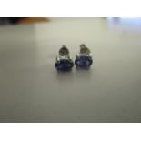 A pair of silver stud earrings set with tanzanites