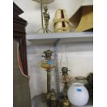 Two Victorian oil lamps with amber glass reservoirs together with a brass oil lamp, additional glass