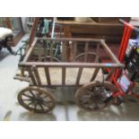 A late 19th/20th century wooden dog cart with slatted sides on spoked wheels