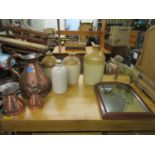 A lot to include three graduated copper jugs, three stoneware flagons and a bottle, a part