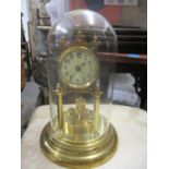 An early 20th century brass Anniversary clock under a glass dome