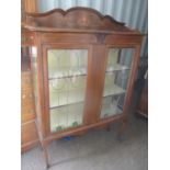 An Edwardian mahogany display cabinet having a raised back with Sheraton Revival inlaid, glass