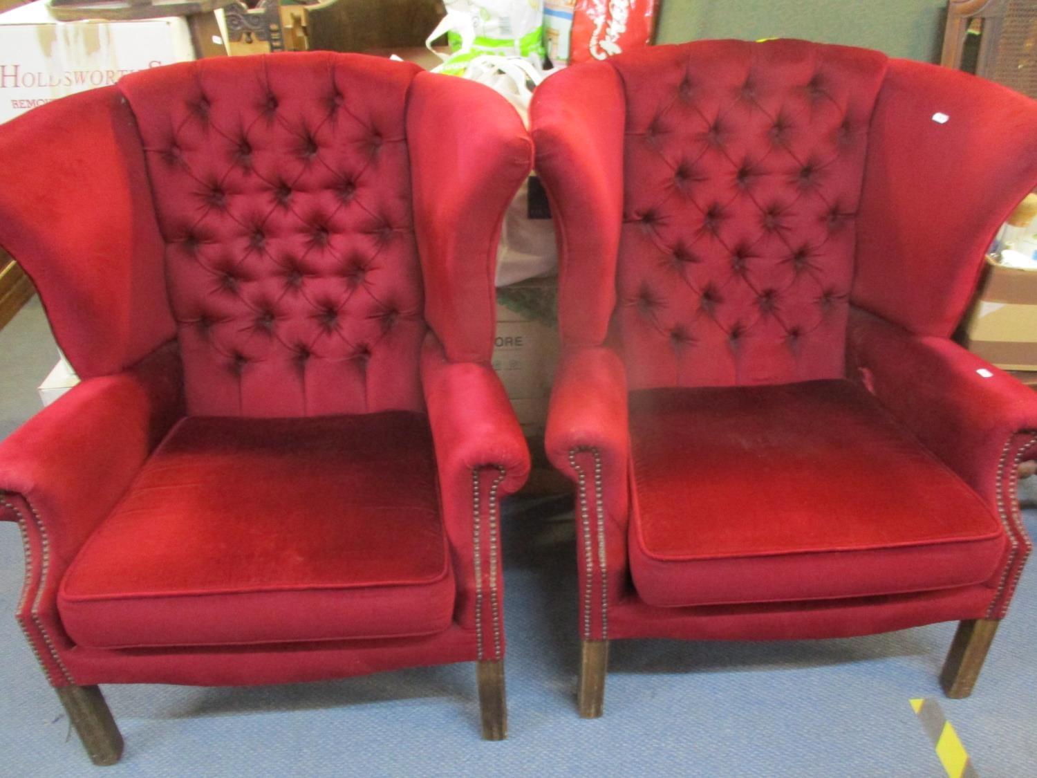 A pair of mid 20th century wing back armchairs in a burgundy valour fabric with stud detail