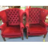 A pair of mid 20th century wing back armchairs in a burgundy valour fabric with stud detail