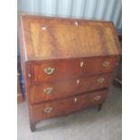 A Georgian mahogany bureau having a fall flap revealing fitted drawers and pigeonholes above three