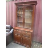 A late 19th/early 20th century walnut bookcase having twin glazed doors above two drawers and two