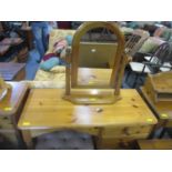 A modern pine dressing table with four graduated side drawers on bun feet, along with a dressing