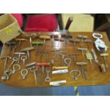 A collection of vintage corkscrews, bottle openers and other items