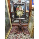 An early Victorian rosewood screen with a tapestry panel, scrolls and turned column on a tripod