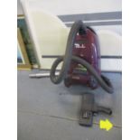 An Electrolux Excellio vacuum cleaner in purple with attachments