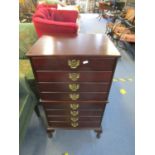 A mahogany effect eight drawer music cabinet on short cabriole legs