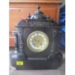 A late 19th century black slate mantle clock fitted with a German 8 day movement, striking on a