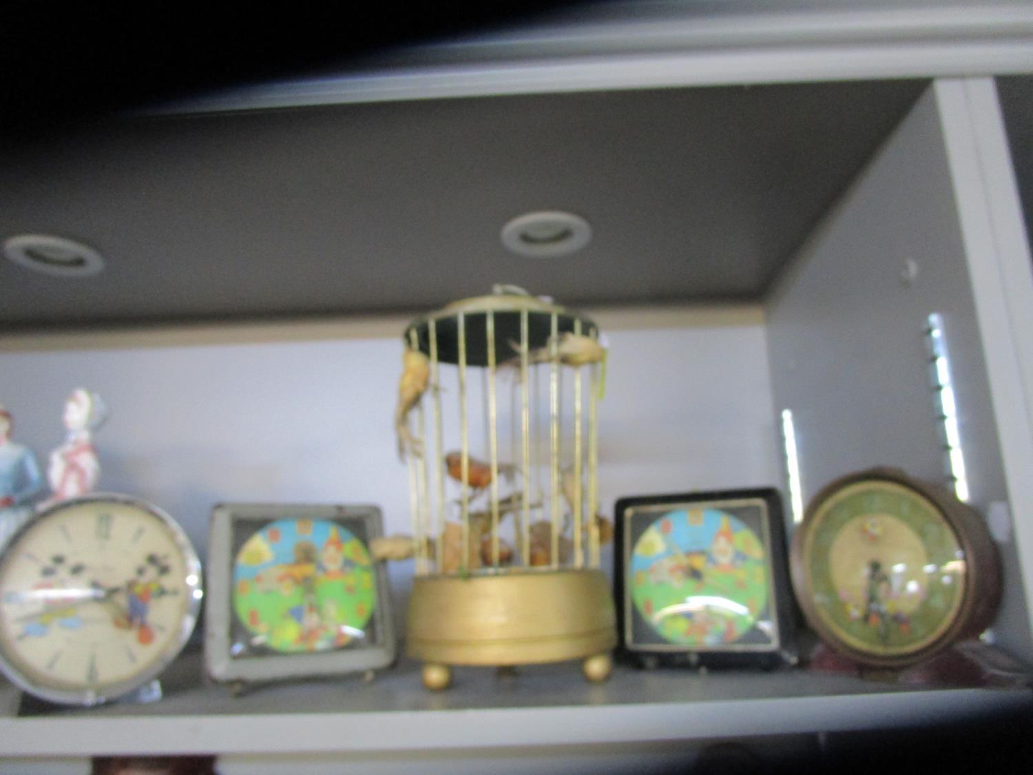 A mid-century musical bird in a cage box, two Noddy alarm clocks and two Mickey Mouse alarm clocks