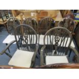 A set of six Windsor wheel back dining chairs with loose cushions (including two carvers)