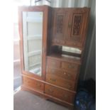 A late Victorian walnut wardrobe having a single mirrored door, two carved cupboard doors and