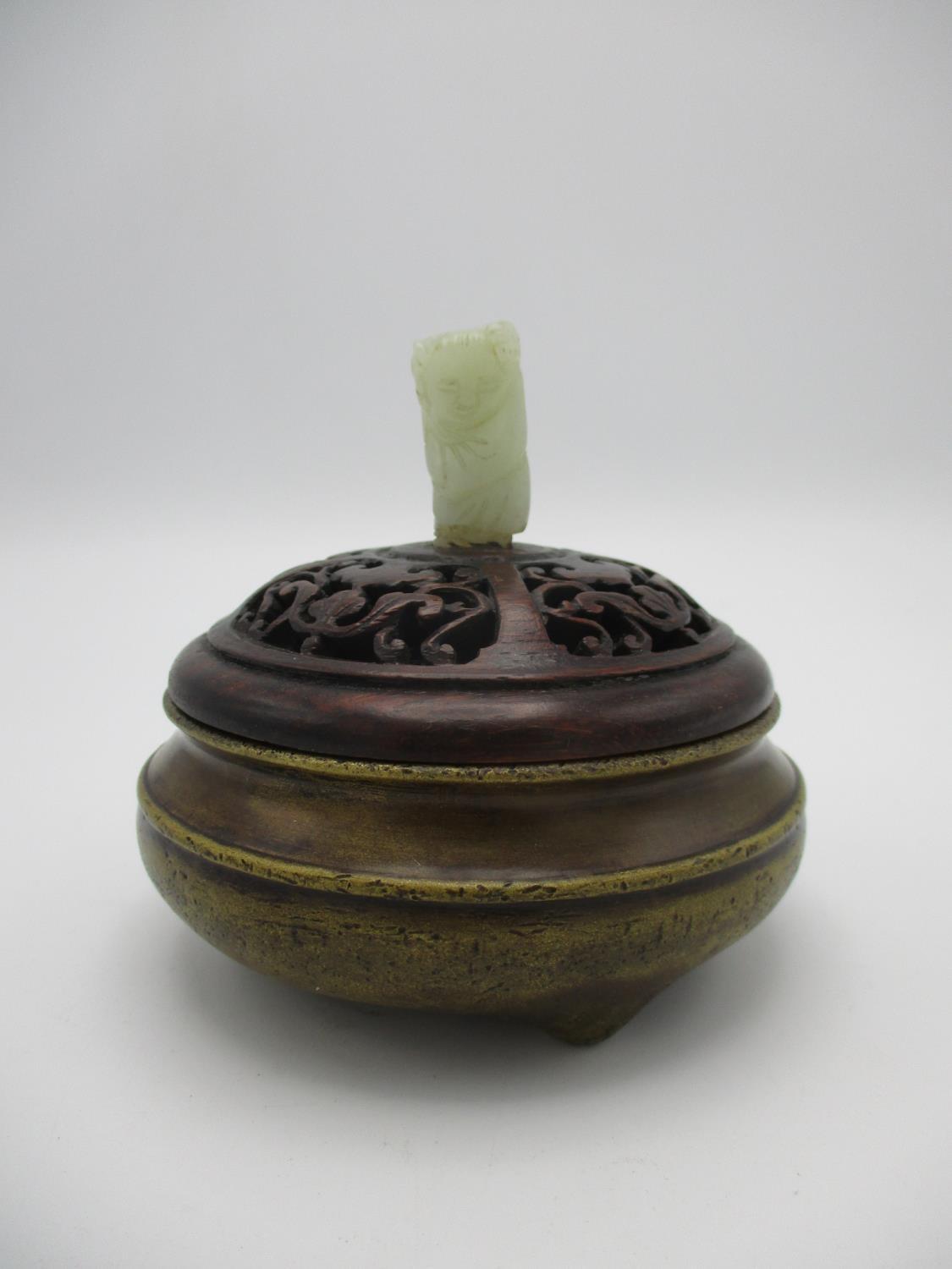 A 20th century Chinese bronze censer having a carved and pierced wooden lid with a carved jade