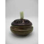 A 20th century Chinese bronze censer having a carved and pierced wooden lid with a carved jade