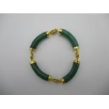 A Chinese jade and gold coloured metal four sectioned bracelet with character decorated links,