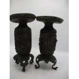 A pair of 19th century bronze vases with broad rims and cylindrical bodies decorated with panels