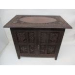 An early 20th century Indian small folding carved hardwood cabinet, decorated with fruiting vines