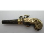 A gold coloured metal and steel watch key fashioned as a pistol with a ratchet mechanism