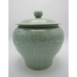 A 19th/20th century Chinese celadon glazed pot and cover, the domed lid having a flower bud