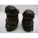 A 20th century Chinese carved wooden foo dogs with a ball, 7" h and another standing astride a foo