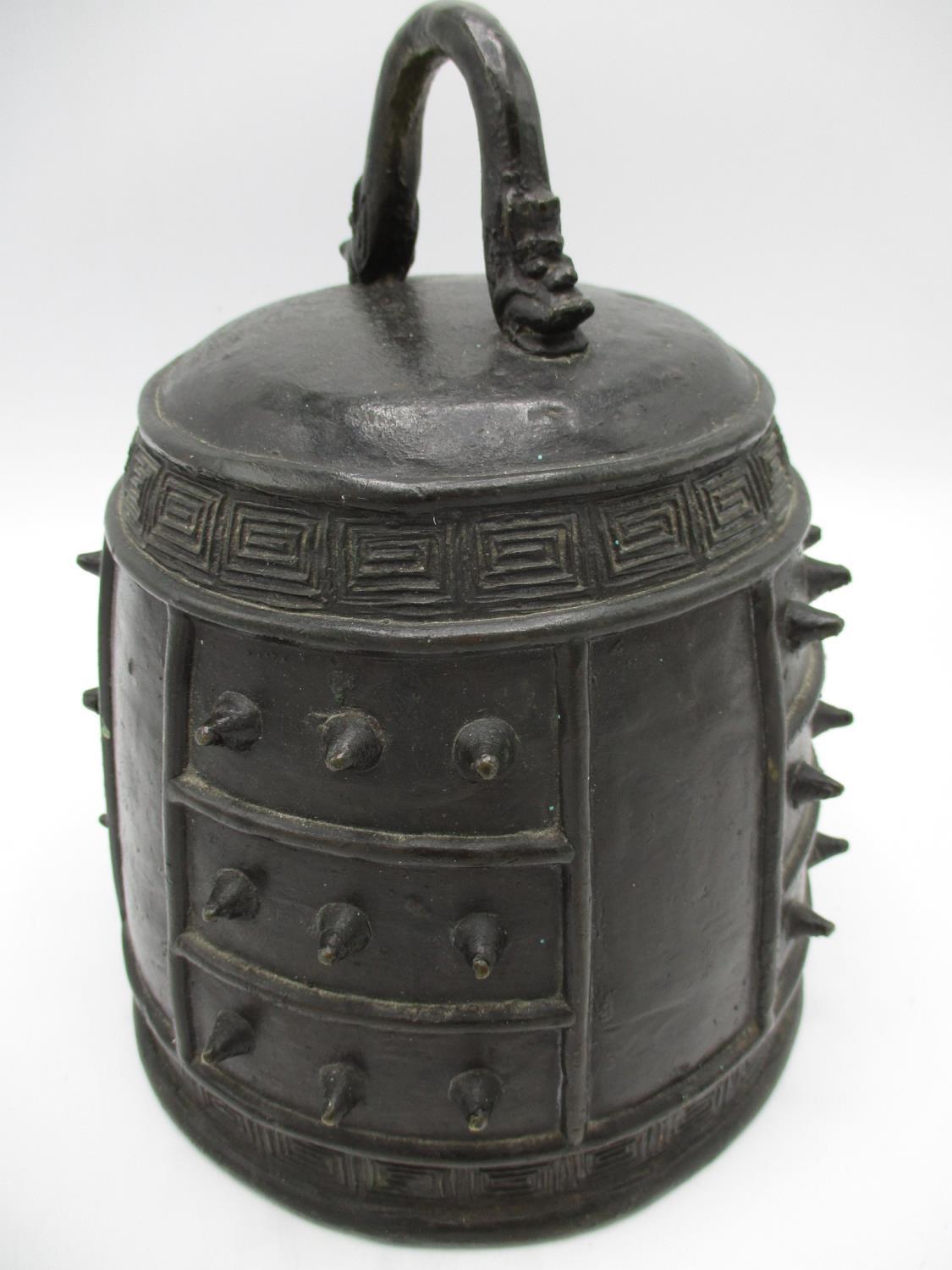 A Qing Dynasty Chinese bronze Bianzhong or chime bell with a twin mask handle, panels of
